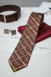 Brown plaid silk tie displayed with matching pocket square and cufflinks.